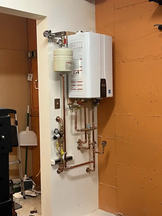 Plumbing technician inspecting water heater connections in Normandy Park